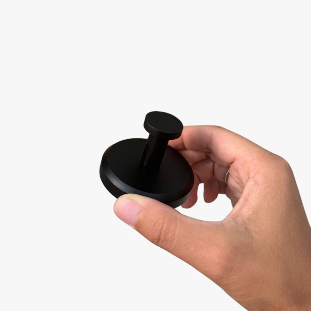 Roselva black suction hook held in hand, featuring a sleek, drill-free design for easy home storage and organization.
