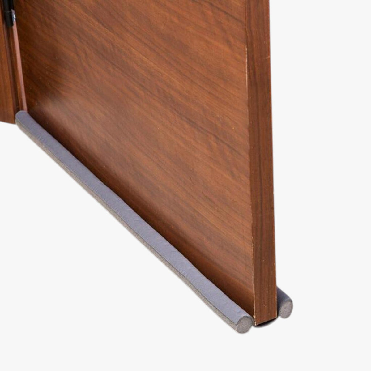 Roselva grey foam double-sided door bottom weather stripping installed on a wooden door to block drafts and noise.