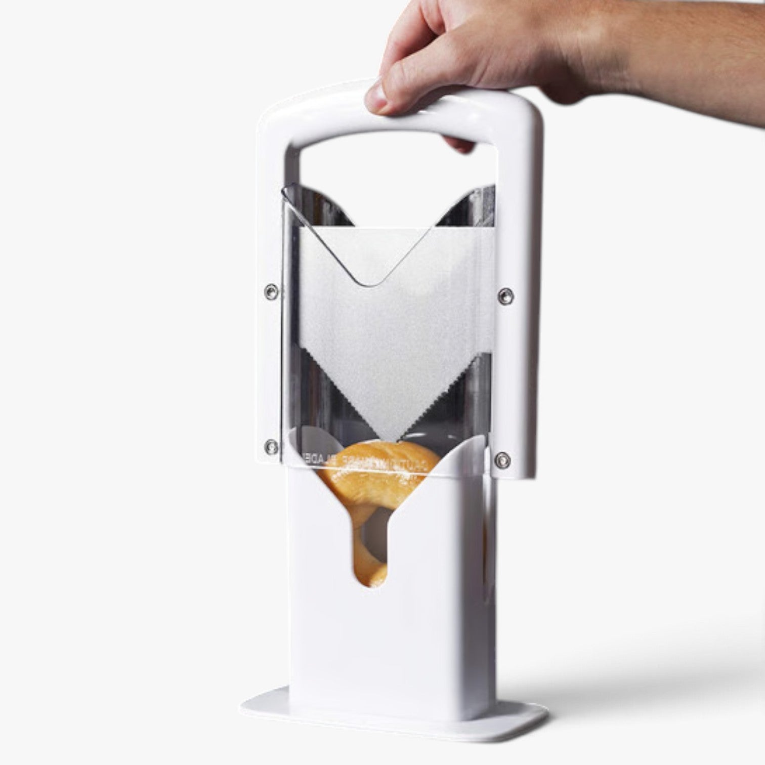 Roselva stainless steel guillotine bagel slicer with a white plastic frame and a hand pressing down the blade